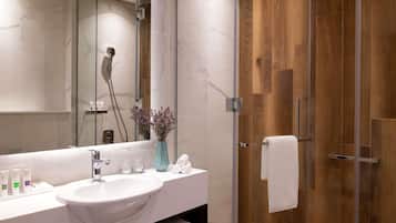 A modern bathroom with a white sink, mirror, and shower.