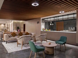 Un interior moderno con barra, asientos y techo de madera.