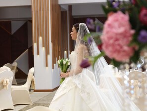 A wedding venue with white chairs, a wooden column, and a floral arrangement. - Swissotel Living Jeddah (Jeddah)