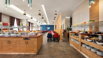 A buffet-style restaurant with multiple serving stations, wooden counters, and a variety of food items displayed.