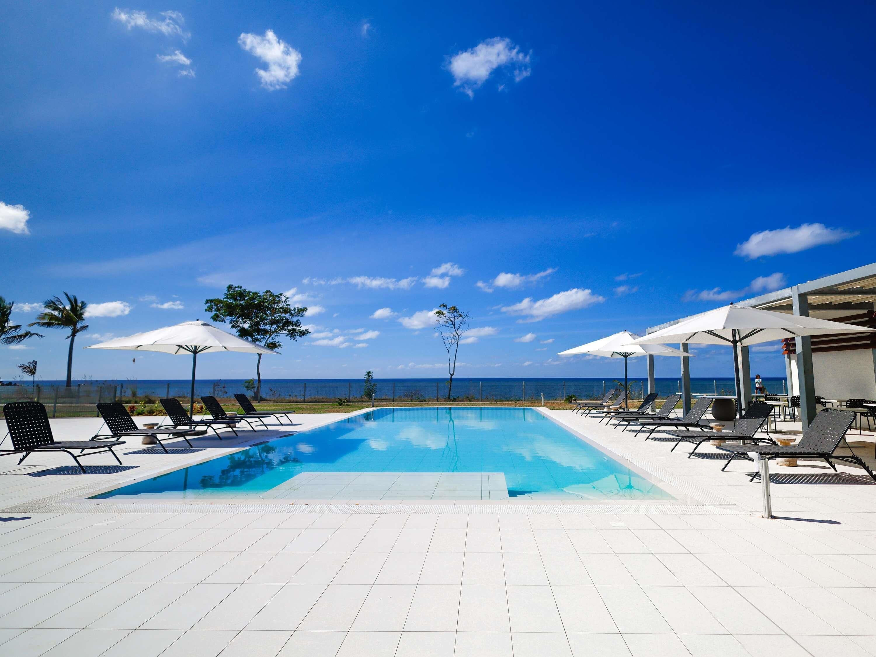 حمّام سباحة خارجي، مظلات على حمّام السباحة، مقاعد للتشمس