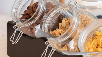 A set of glass jars with metal clasps containing various food items.