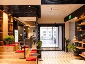 A modern interior with wooden shelves, red cushioned seating, and a patterned floor. - Ibis Lviv Centre (Lviv)