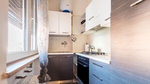 A compact kitchen with a stove, oven, and sink. - Holiday Apartment "Locazione Panta Rei" with A/C & Wi-Fi (Verona)