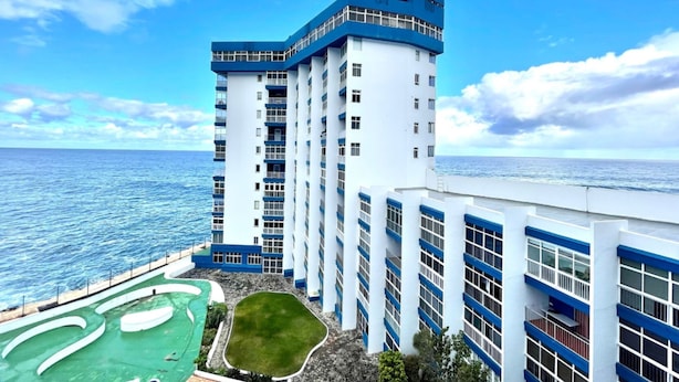 Un hôtel de grande hauteur doté d’une piscine et offrant une vue sur l’océan.