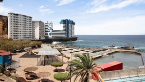 Un hôtel situé sur la côte, doté d’une piscine, d’un espace de jeux pour enfants et offrant une vue sur la mer.