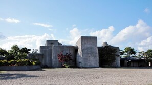 Unique geometric structure with a striking design, set amidst a serene open area.