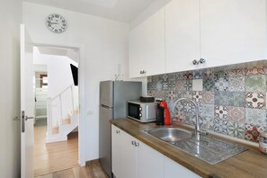 A kitchen with white cabinets, a microwave, a coffee maker, and a sink with a tiled backsplash. - Vacation Home 'Casa Micaela 2' with Sea View, Terrace, Balcony & Wi-Fi (El Sauzal)