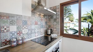 A kitchen with a patterned backsplash, a window with a view, and a stainless steel kettle on the counter. - Vacation Home 'Casa Micaela 2' with Sea View, Terrace, Balcony & Wi-Fi (El Sauzal)