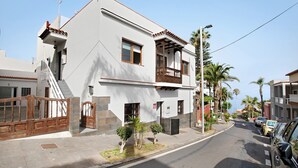 A two-story building with a balcony, a gated entrance, and a clear sky. - Vacation Home 'Casa Micaela 2' with Sea View, Terrace, Balcony & Wi-Fi (El Sauzal)