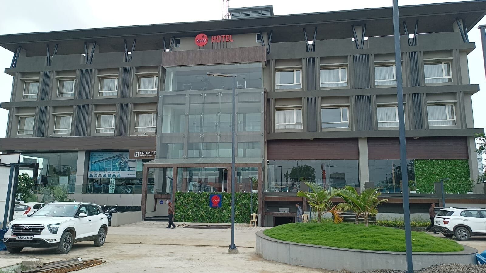 A modern hotel building with a glass facade, multiple floors, and a sign indicating it is a Spree Hotel.
