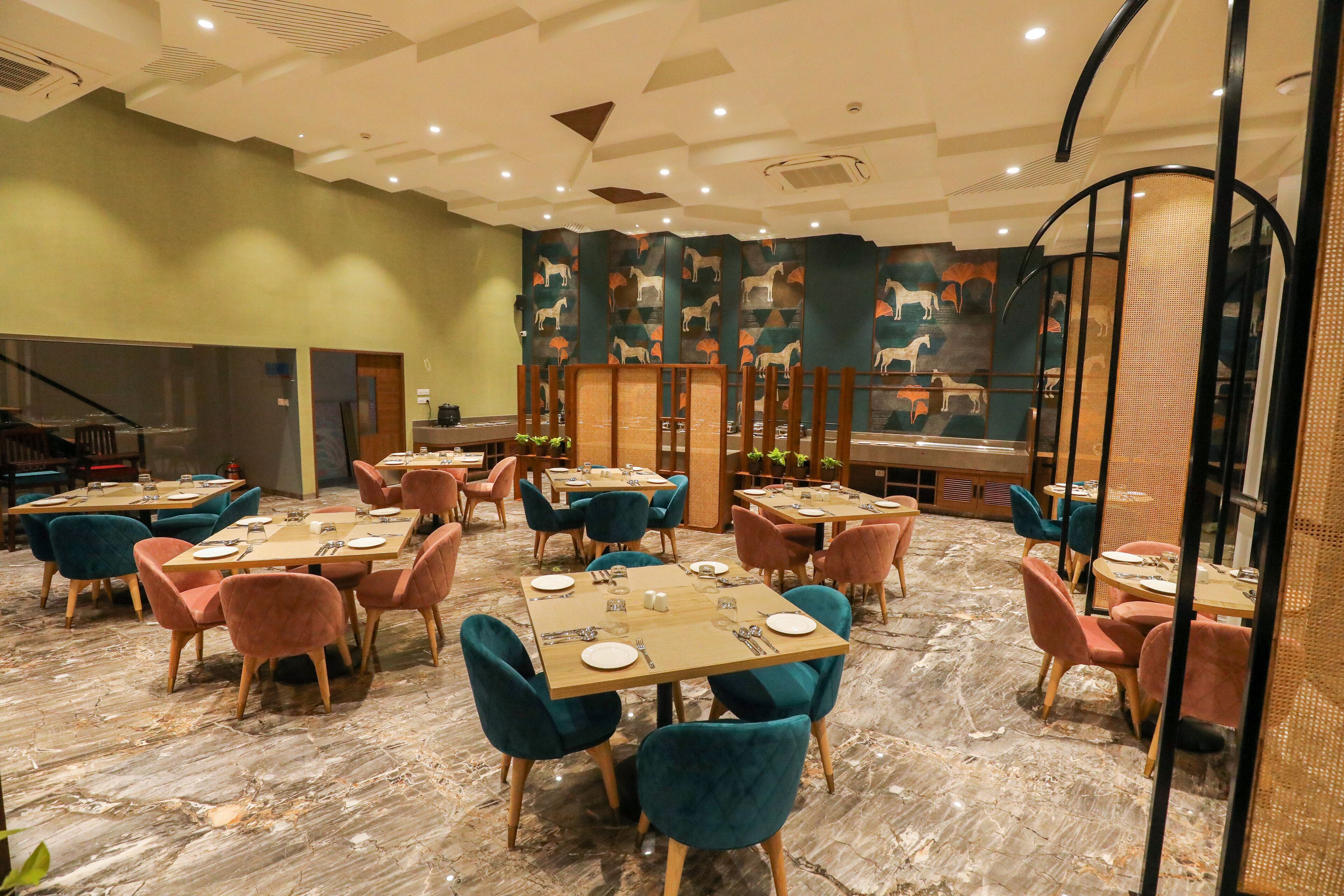 Ein Restaurant mit mehreren Tischen und Stühlen, einer Wand mit Muster und einem Marmorboden.