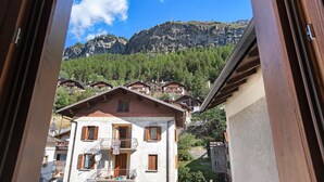 Une vue sur la montagne avec un balcon en bois, un bâtiment doté d’un balcon et une montagne en arrière-plan.