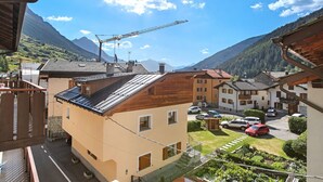 Un quartier résidentiel avec des maisons, une grue et des montagnes en arrière-plan.