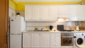 A kitchen with white cabinets, a refrigerator, a sink, a stove, a washing machine, and a dishwasher. - Apartment 'Algarvio Ao Sol' with Balcony, Wi-Fi and Air Conditioning (Conceição de Tavira)