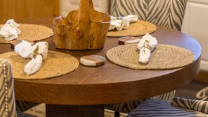 A round wooden table with woven placemats and folded white napkins. - Ramblin Rose, Apartment in Central Area, Sleeps 4 (Sequim)