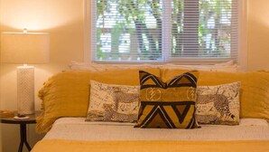 A bed with two leopard-print pillows, a lamp, and a window with blinds. - Ramblin Rose, Apartment in Central Area, Sleeps 4 (Sequim)