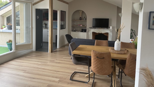 A modern living room with a dining area, a fireplace, and a television. - Grand Appartement Terrasse Hypercentre (Poitiers)