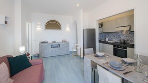 Moderni huoneisto, jossa on olohuone, keittiö ja ruokailutila.