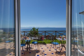 A terrace with outdoor seating, a view of the sea, and a clear sky. - Villa Euriclea - Mediterranean Elegance in the Heart of Praiano (Praiano)
