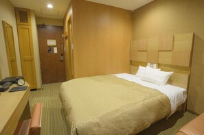 Relax in a spacious room with a large bed, wooden headboard, and comfortable seating area.