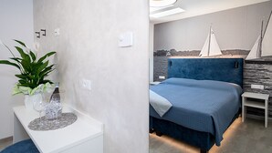 Een moderne slaapkamer met een bed, nachtkastjes, een slaapkamerplant en een wandlamp.