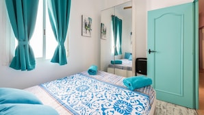 Een slaapkamer met een bed, een spiegel en een deur.