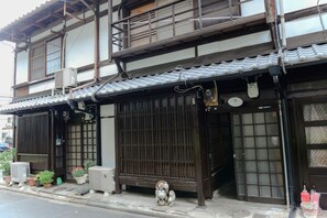 Traditional Japanese building with sliding doors and potted plants.