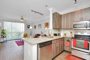 Enjoy cooking in this well-equipped kitchen with a central island, stainless steel appliances, and ample cabinetry.