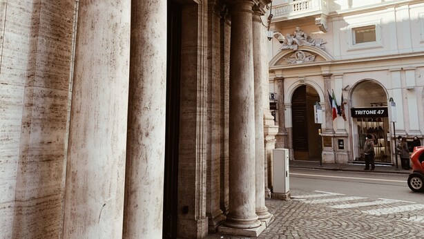 A historic building with classical architecture, featuring large columns and an arched entrance.
