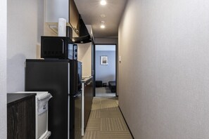 Cozy accommodations feature a compact kitchenette with a refrigerator, microwave, and sink.