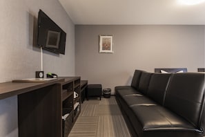 Relax in a stylish room with a flat-screen TV, comfortable sofa, and a cozy reading nook.