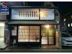 Traditional Japanese architecture meets modern style in this urban setting, featuring a tiled roof and traditional gate.