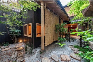 Traditional Japanese-style building with a serene atmosphere, featuring a cozy interior and lush greenery.