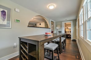 A modern kitchen with a wooden island, built-in shelves, and a large window.