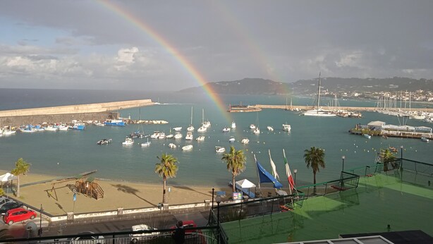 A coastal marina with boats, a beach, and a rainbow. - Captivating 2-bed Villa in Forio - Enjoy a Yacht (Forio)