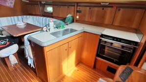 A compact kitchen with a sink, stove, and storage cabinets. - Captivating 2-bed Villa in Forio - Enjoy a Yacht (Forio)