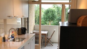 Eine moderne Küche mit Einbauofen, Spüle und Essbereich mit Tisch und Stühlen.
