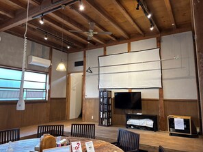 Enjoy a spacious room with a high ceiling and exposed beams, perfect for dining, meetings, or presentations.