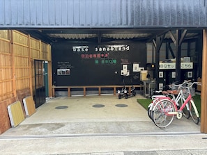 Base Sanablend's entrance features a wooden door and a bench, with bicycles parked nearby.