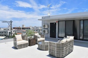 Relax on the rooftop with a seating area, wicker furniture, and a city view.