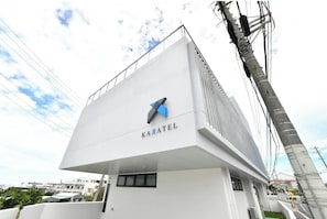 A modern building with a white facade and a logo that reads "KARATEL".