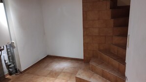 A corner of a room with a tiled floor, a staircase with brown tiles, and a white wall. - Kleines Ferienhaus im Zentrum von Bad Schandau (Bad Schandau)