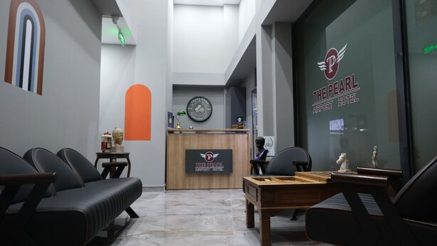 A hotel reception area with a reception desk, a clock, and a pool table. - The Pearl Airport Hotel (Arnavutköy)