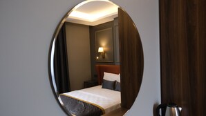 A hotel room with a bed, a nightstand, a lamp, and a coffee maker. - The Pearl Airport Hotel (Arnavutköy)