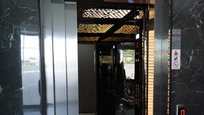 An elevator with a digital display, marble walls, and a patterned ceiling. - The Pearl Airport Hotel (Arnavutköy)