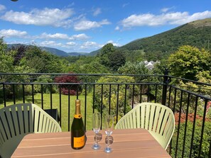 Ein Balkon mit Tisch, zwei Stühlen, einer Flasche Veuve Clicquot Champagner und zwei Gläsern.