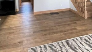 Un vaste espace de vie agrémenté d’un escalier en bois, d’un téléviseur à écran plat fixé au mur et d’une cuisine équipée d’appareils électroménagers modernes.