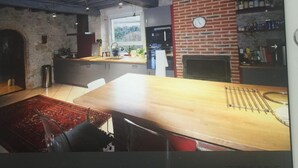 Eine moderne Küche mit einem großen Holztisch, einer Ziegelwand und einem Fenster mit Blick.