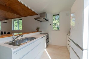 A modern kitchen with a wooden countertop, stainless steel sink, and built-in appliances.